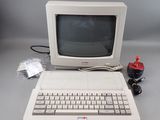 un vieil ordinateur avec un clavier et une souris posés sur la table