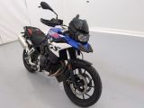 une moto bleue et blanche garée dans une pièce blanche