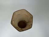 a glass vase with a brown liquid inside of it