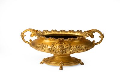 un vase en or posé sur une surface blanche