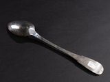a spoon that is sitting on a black surface