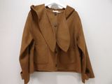 brown wool jacket with hood on hanger on white wall