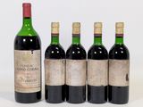 four bottles of wine are lined up in a row on a white surface