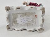 a small figurine of a cat sitting in a picture frame