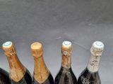 six bottles of wine are lined up in a row on a table