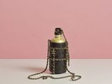 une bouteille noire entourée d'une chaîne, posée sur une table