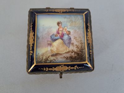 a small box with a painting on it on a table