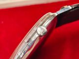 an image of a close up of a watch on a red cloth