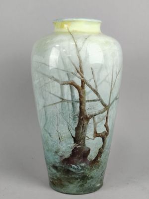 un vase orné d'un arbre, posé sur une table