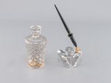une petite bouteille en verre avec un stylo à côté