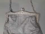 an antique silver mesh purse with a chain strap and clasp