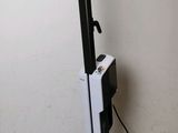 a black and white vacuum on the floor next to a white wall