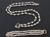 un collier et un bracelet de perles blanches avec un fermoir en or