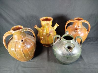 four different colored vases are lined up on a black background