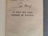 un livre ouvert avec une écriture manuscrite posé sur une table