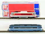 two model trains sitting on the tracks next to each other