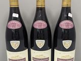 trois bouteilles de vin sont alignées sur une table