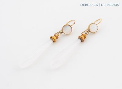 a pair of earrings with clear quartz and gold