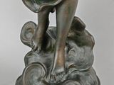 bronze statue of a boy holding a fish on a rock
