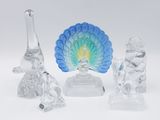 trois figurines en verre représentant des animaux et un paon, posées sur un fond blanc
