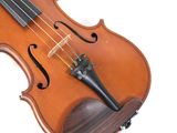 an old violin sitting on top of a wooden stand on a white surface