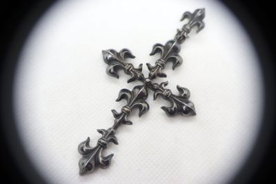 a cross made out of metal on a white surface