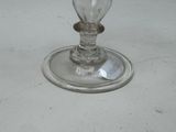 a glass candle holder on a table with a tag on it