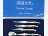 four pieces of silverware in a blue box on a white surface