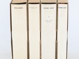 trois livres sont empilés sur une surface blanche
