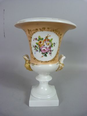 un vase blanc orné d'une anse dorée et d'un motif floral