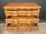 a wooden dresser with three drawers on top of it