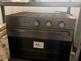 a silver oven that is on a shelf in a room