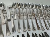many spoons and forks laid out on the table