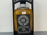 une bouteille de whisky posée sur une table à côté d'une boîte