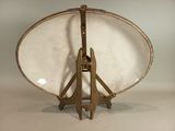 a white plate with a gold handle on a stand