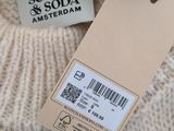 the label on the sweater is attached to the tag