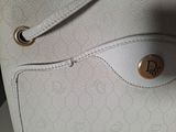 a close up of a white purse with a gold button