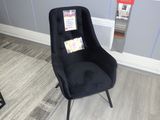 une chaise noire qui se trouve dans un coin de la pièce