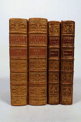several old books are lined up in a row on a white surface