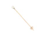 a gold and pearl stick pin with a single pearl on it