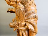 une statue en bois représentant un homme tenant un oiseau