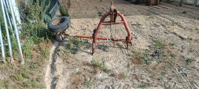 un tracteur qui est à l'arrêt dans la terre, près d'une clôture