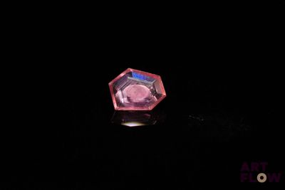 an image of a pink diamond sitting on top of a black surface