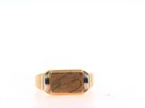 a close up of a gold ring with a tiger ' s eye stone