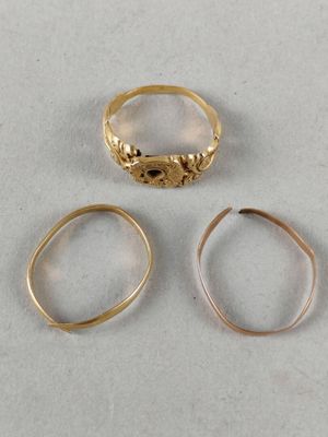 three different types of gold rings on a white surface