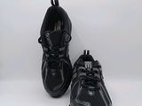 un gros plan sur une paire de chaussures de course noires posées sur une surface blanche