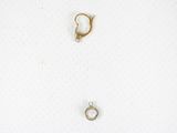 two gold rings and a silver ring on a white surface