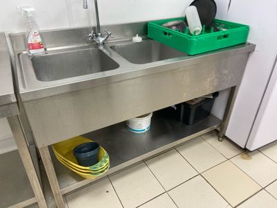 two sinks in the kitchen with a green basket on the counter
