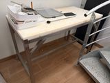 un bureau sur lequel se trouve un ordinateur portable, à côté d'un escalier