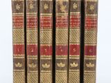 cinq vieux livres sont alignés sur une surface blanche
